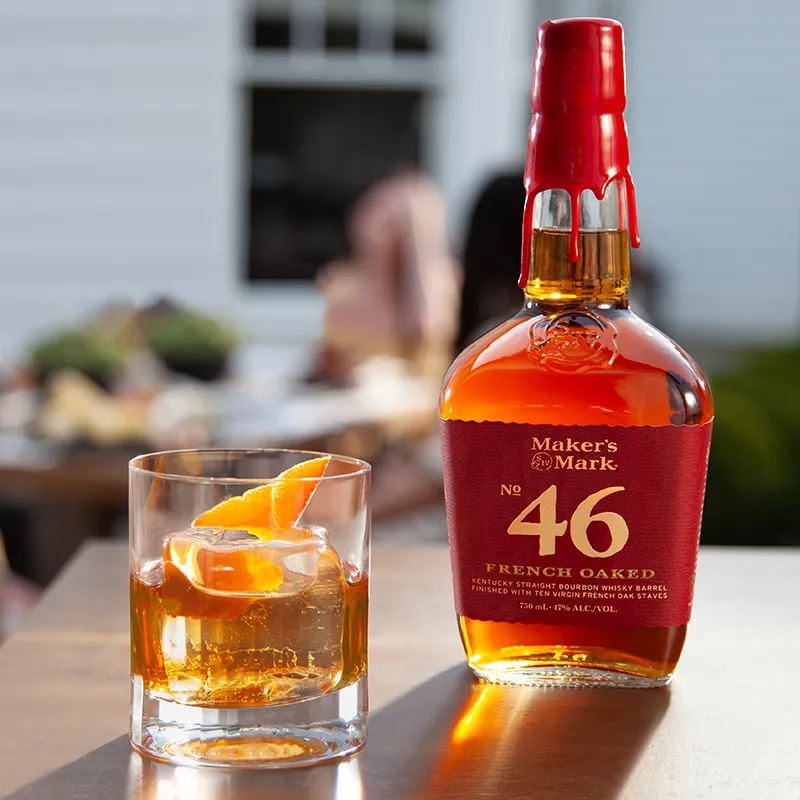 Summer Manhattan bottle and glass garnish with orange peel